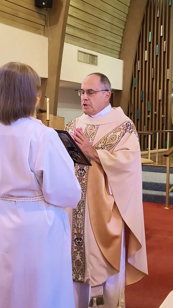 A priest is holding his hands out to someone.