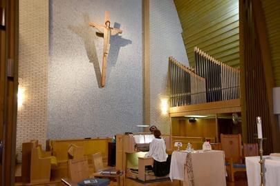 Church organist playing at pipe organ.