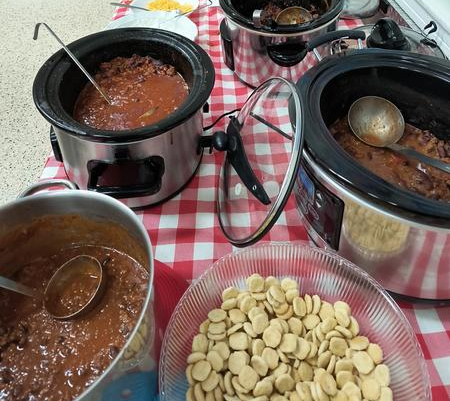 A table with bowls of food and pots on it.