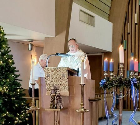 A priest is giving a sermon in front of the altar.