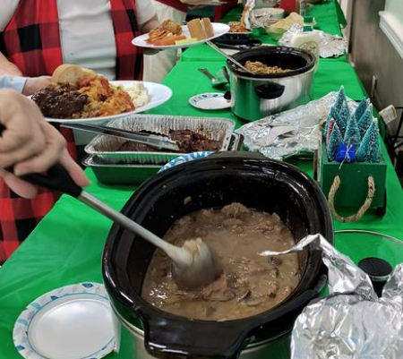 A table with people eating food and drinking.